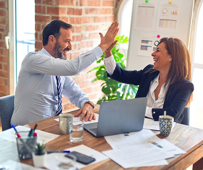 Professionnels en réunion autour d’un ordinateur, illustrant le support informatique pour PME en Wallonie